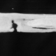 Sagoma nera di uomo che corre su fondo nero con parte centrale bianca, fotogramma da Z.O.