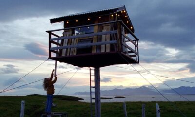 Nest, ragazza che guarda verso il rifugio sopraelevato mantenendo un bastone