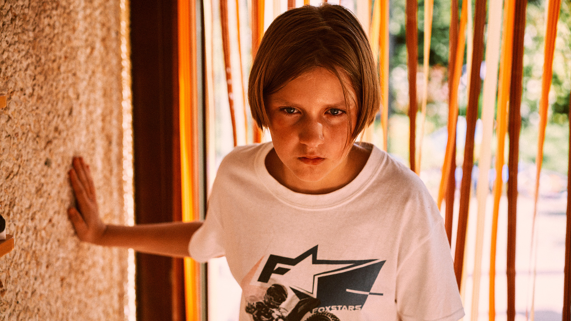 LA RAGAZZA DI GHIACCIOOra, adulta e solitaria, lavora come assistente di un fotografo e vive con la sorella minore. Quando la sorella decide di trasferirsi, Eva si ritrova completamente sola, e il passato riaffiora con prepotenza. La notizia di una riunione di vecchi amici del villaggio diventa per lei l’occasione per affrontare i fantasmi che l’hanno segnata per sempre. Riviviamo con lei, quell’estate della sua adolescenza che ha cambiato la sua vita. Eva (Rosa Marchant) è cresciuta tra una madre (Naomi Velissariou) alcolizzata e un padre (Sebastien Dewaele) irascibile, per questo cercava attenzione da parte dei due amici maschi del villaggio, Tim e Laurens (Anthony Vyt e Matthijs Meertens). Si lasciava coinvolgere in giochi sempre più pericolosi e crudeli, ritrovandosi impotente di fronte alla loro violenza e al silenzio degli adulti. Quell’estate segna il suo passaggio dall’infanzia all’adolescenza e lascia cicatrici profonde nella sua psiche. la ragazza di ghiaccio